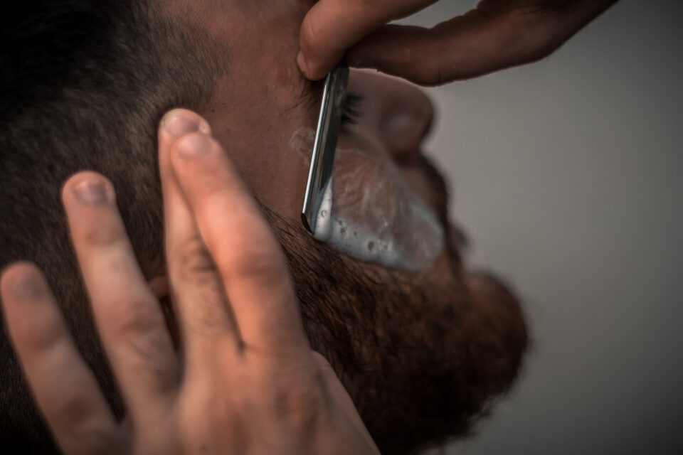 Barber trimming a beard with scissors