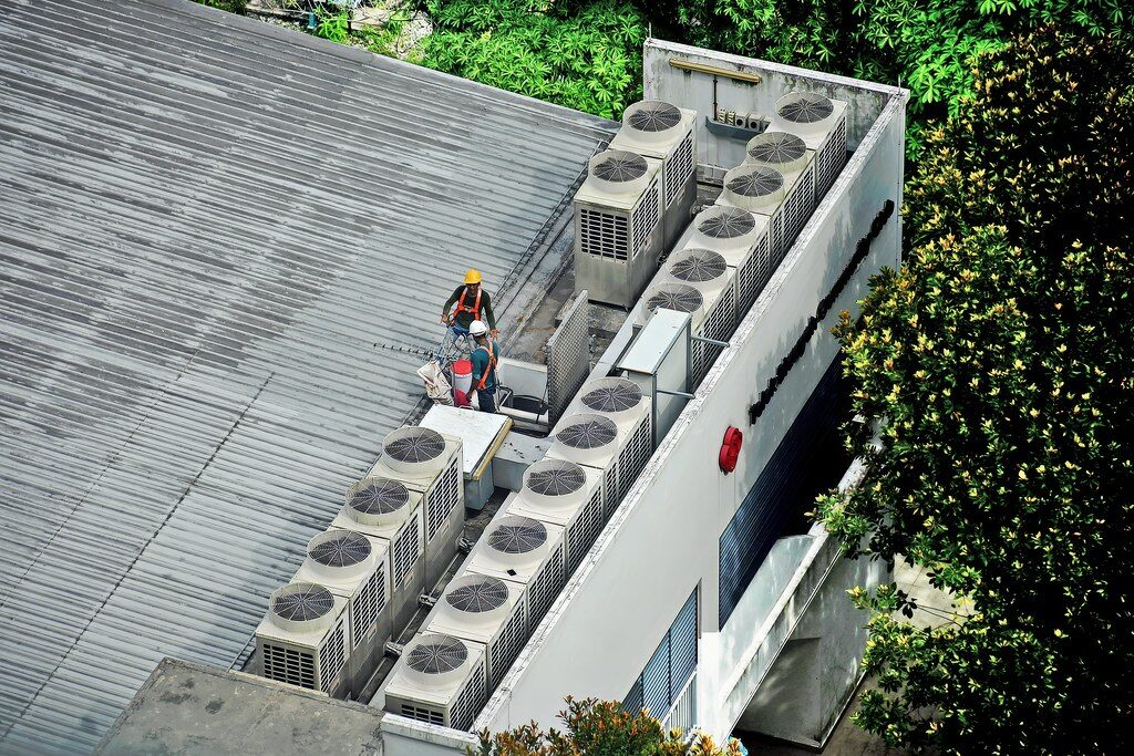 A technician working among rooftop air-conditioning units