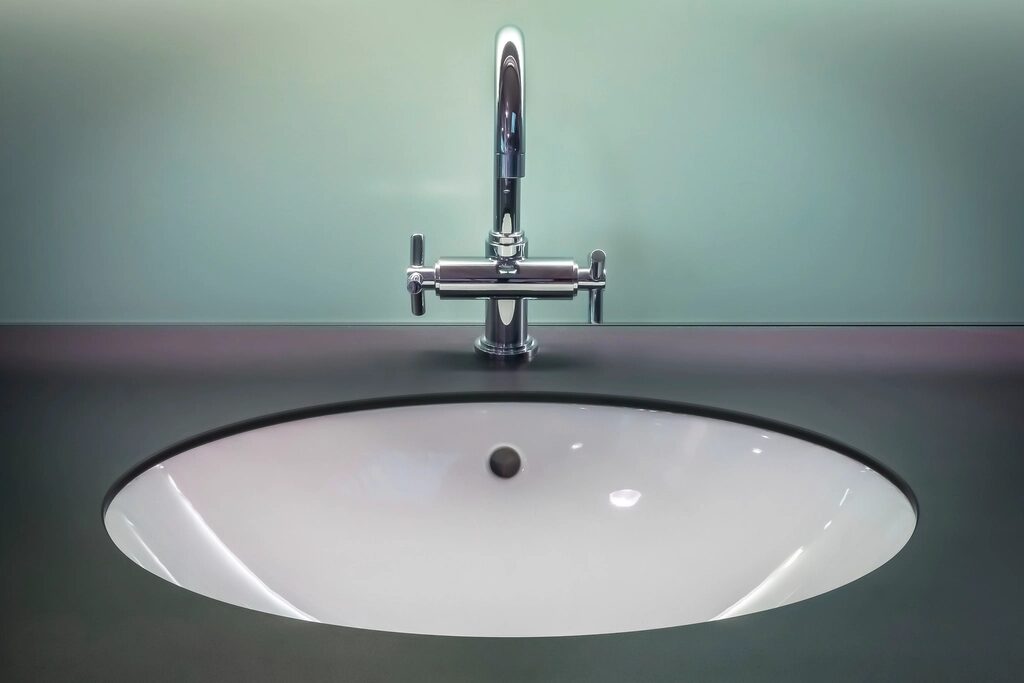 A chrome tap over a round basin