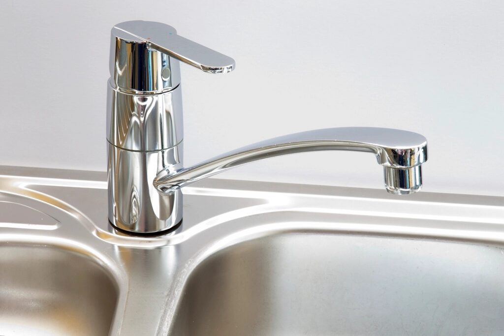 Chrome kitchen mixer tap beside a steel sink
