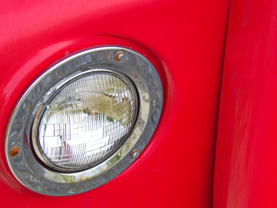 Round headlight lens on a red car